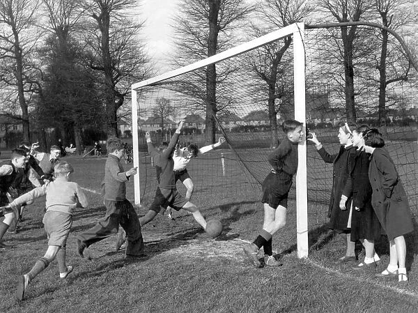 Young goalkeeper is distracted by a group of girls, as a goal is scored, , 20th April 1951