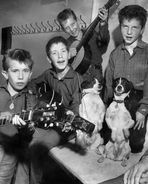 Framed Print : Young group of boys holding their guitars as they practice watched by their pet dogs Framed Print : Young group of boys holding their guitars as they practice watched by their pet dogs