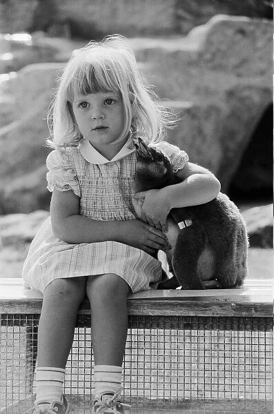 Young Kirsten Ogilvie with a baby penguin at the Cotswold WildLife Park in Oxfordshire
