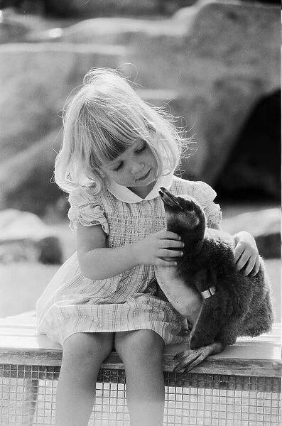 Young Kirsten Ogilvie with a baby penguin at the Cotswold WildLife Park in Oxfordshire