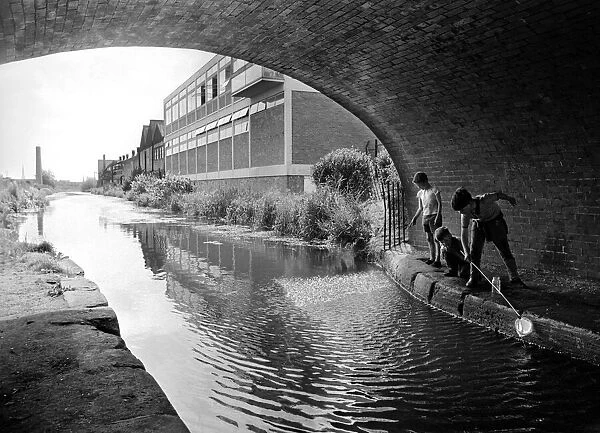 These young lads are having fun fishing with a net in the Coventry Canal at the Cash