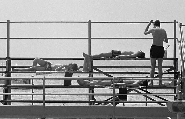 Four young lads sun bathing after taking a dip in the sea at Southend, Essex