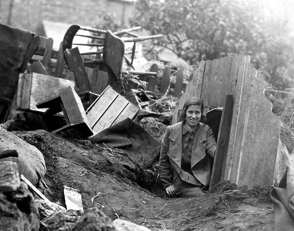A young lady emerges from an Anderson Shelter after an air raid
