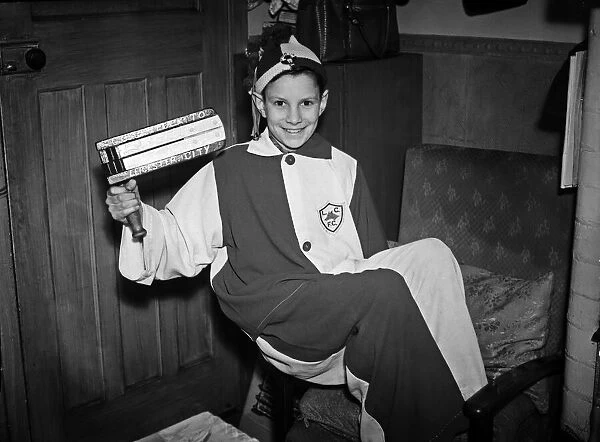 Young Leicester City football club mascot holding his rattle wearing his costume