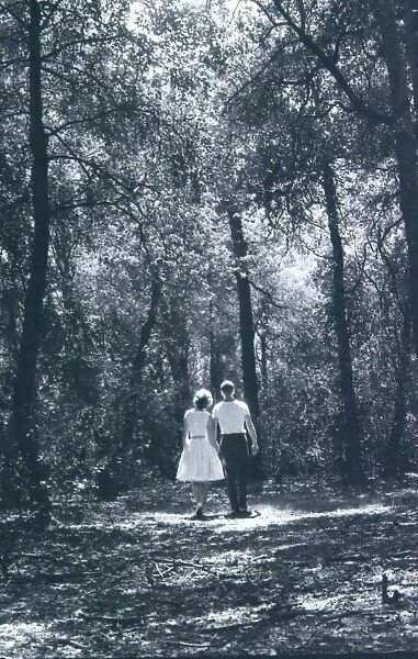 Young lovers walking hand in hand through Sutton Park