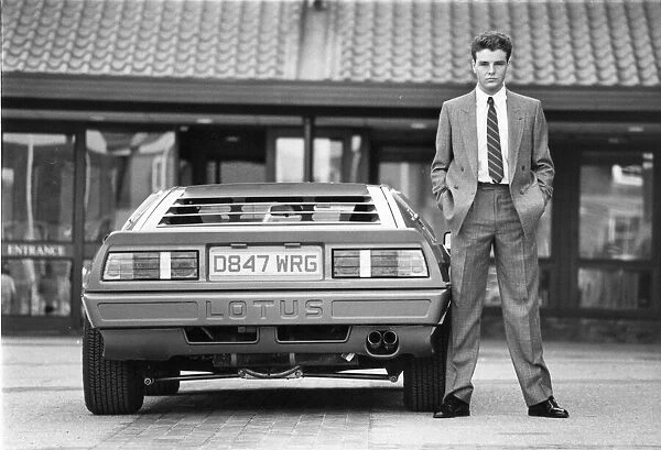 A young man posing in the latest suit with a must have accessory - a Lotus car