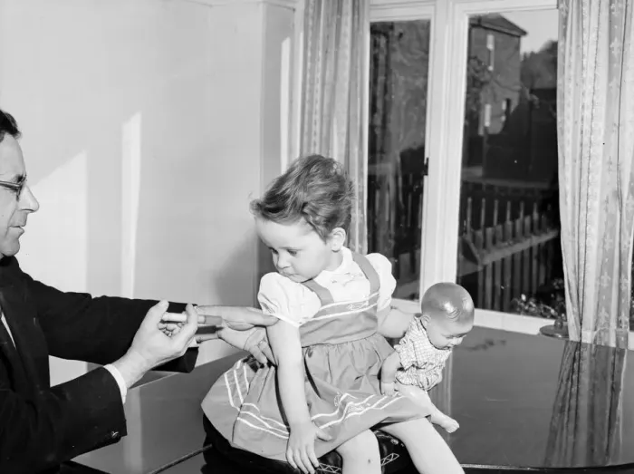 Framed Print : A young patient looks on with trepidation whilst having her polio vaccination Framed Print : A young patient looks on with trepidation whilst having her polio vaccination
