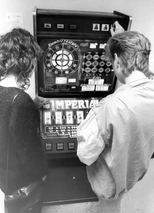 Framed Print : Young people playing on a one armed bandit or electronic gaming machine in September 1983