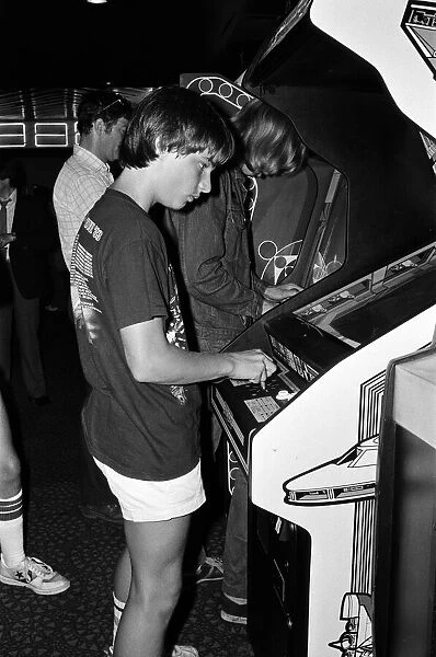 Young people playing video games in an amusement arcade in London. 13th July 1983
