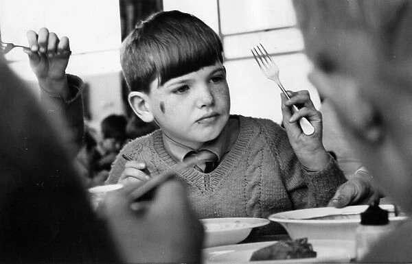 A young pupils enjoying his school lunch