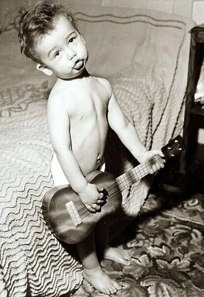 A young rock star playing is guitar. Circa 1950