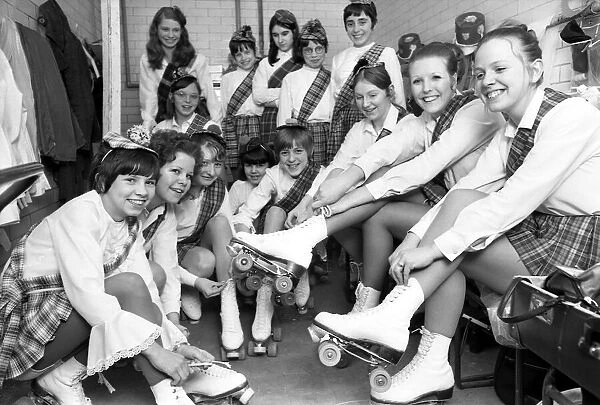 Young roller skaters lace up their boots and chat back stage as they prepare to take part