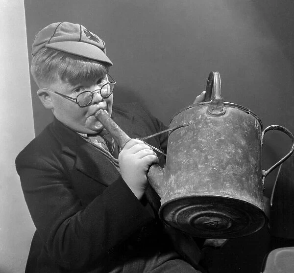 Young schoolboy John Toll tunes up on his watering can before taking part in auditions