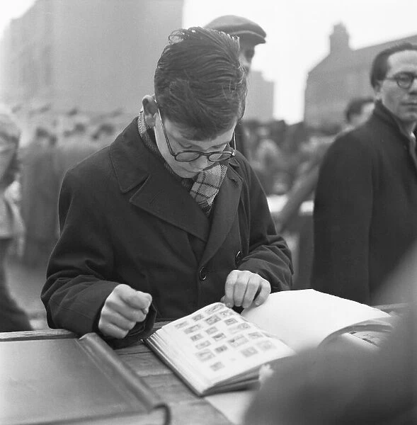 A young stamp collector looking to add to his collection at the flea market in Club Row