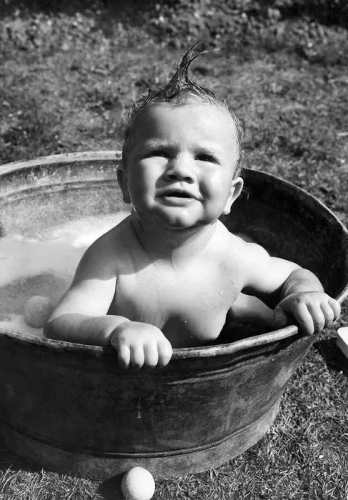 Framed Print : Young toddler having a wash in a tin bath in the back garden in Erith, Kent