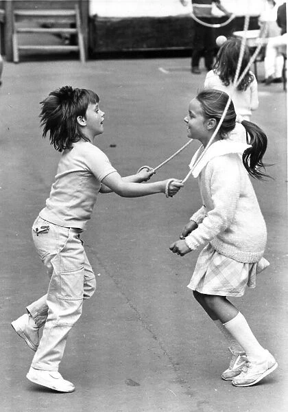 Two youngsters enjoying playtime with a spot of skipping