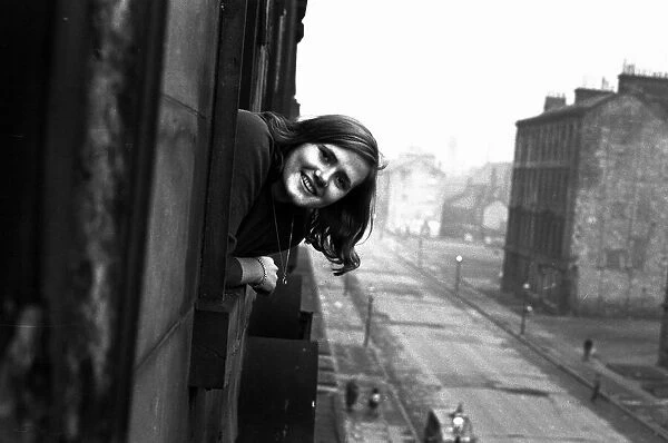 A youth worker pops her head out of one of the windows in a housing slums in the Gorbals