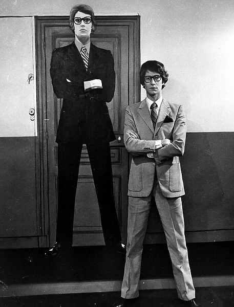 Yves Saint Laurent standing in front of a cardboard cartoon cut out of himself