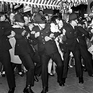 10 July 1964 Police holding back crowds of fans, who are waiting to see The Beatles