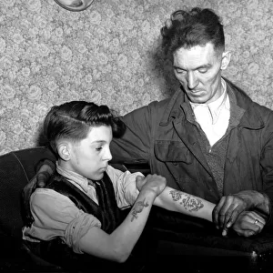 14-year-old Arthur Waterworth of Droylsden shows off his tattooed forearms to his father