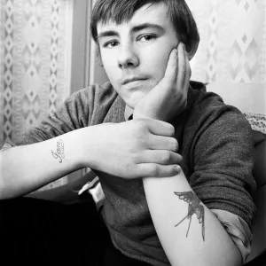Black and white photograph print of a 14-year-old boy with tattoos