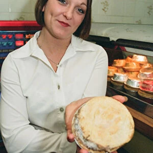 21 year old barmaid Sarah Pilcher holds up a steak and kidney pie in a fish and chip shop