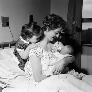 3-year-old Louisa, daughter of Brian Rix and Elspet Gray, meets her new baby brother