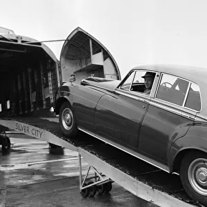 Actor Alec Guinness loading his Bently onto an aircraft bound for France where he will