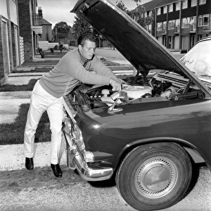 Actor Johnny Briggs fixing his car at home. Circa 1963