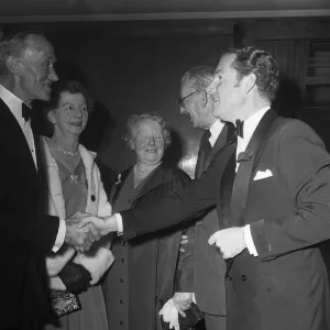 Actor Kenneth More shakes hands with Mrs E Daniels of Portsmouth who was a survivor of