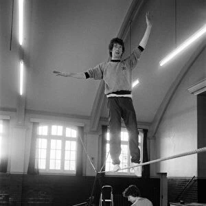 Actor Michael Crawford works out on the high wire with a charlady sweeping the floor