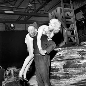 Actor Sidney James carrying Liz Fraser on set at Twickenham Studios were they are making