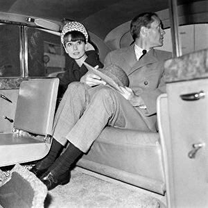 Actress Audrey Hepburn and her husband Mel Ferrer in the back of a car. 3rd April 1964