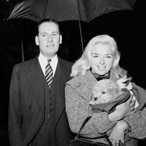 Actress Diana Dors holding her pets as she arrives at court on assault charges