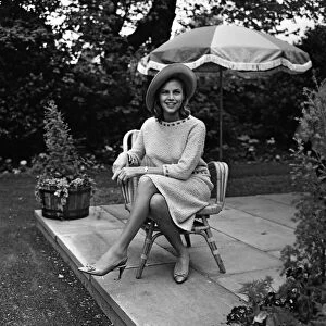 Actress Honor Blackman relaxes in her garden party outfit during the filming of