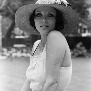 Actress Joan Collins modelling outfits that she will wear on a trip to Tokyo to judge a