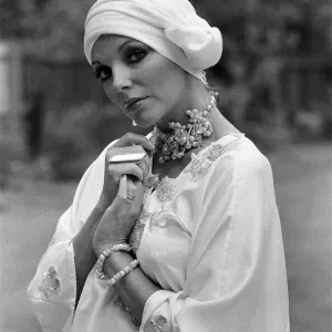 Actress Joan Collins modelling outfits that she will wear on a trip to Tokyo to judge a