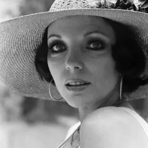Actress Joan Collins modelling outfits that she will wear on a trip to Tokyo to judge a