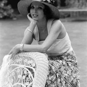 Actress Joan Collins modelling outfits that she will wear on a trip to Tokyo to judge a