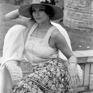 Actress Joan Collins modelling outfits that she will wear on a trip to Tokyo to judge a