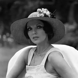 Actress Joan Collins modelling outfits that she will wear on a trip to Tokyo to judge a