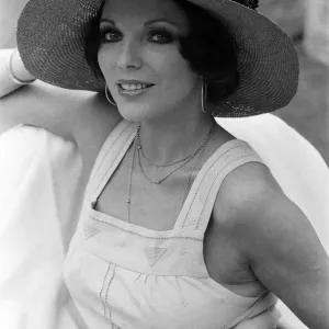 Actress Joan Collins modelling outfits that she will wear on a trip to Tokyo to judge a