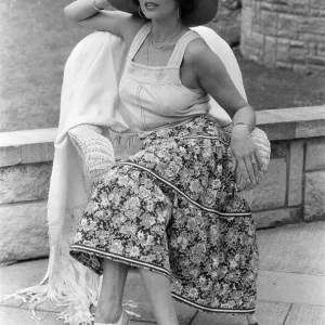 Actress Joan Collins modelling outfits that she will wear on a trip to Tokyo to judge a
