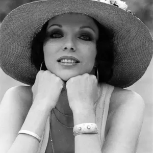 Actress Joan Collins modelling outfits that she will wear on a trip to Tokyo to judge a