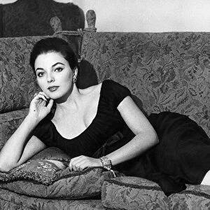 Actress Joan Collins poses on her sofa June 1956