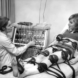 Black and white print of Paula Byrne operating a slimming machine