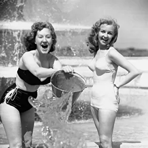 Aileen Kearney (right) and her friend Marjorie Greenhalgh throwing a bucket of water over