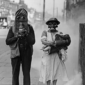 Air raid warden with nurse and baby in arms seen demonstrating the new gas helmet during