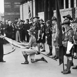 Print of Alderman Kelly pinning the Scouts Silver Cross to a flag