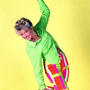 Alison Douglas TV Presenter with hair tied up wearing bright coloured trousers